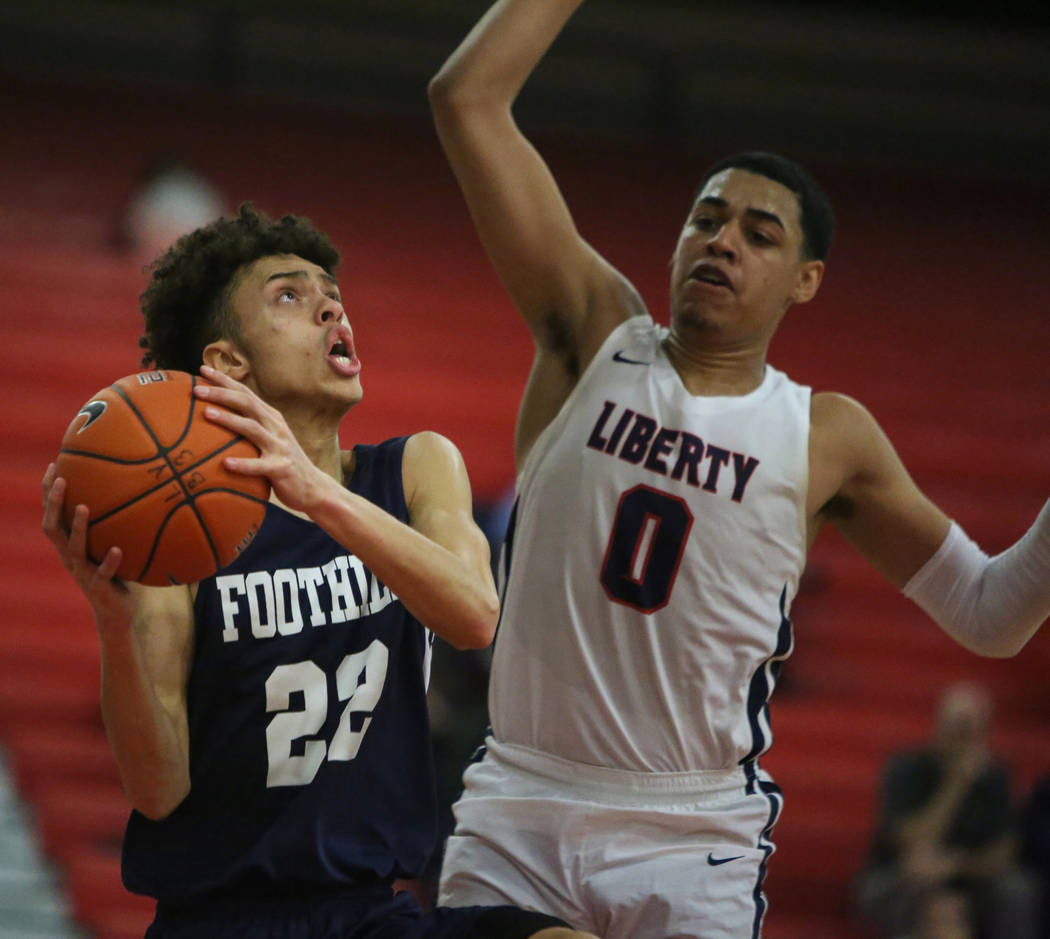 Foothill's Jace Roquemore (22) drives to the net while under pressure from Liberty's Julian Str ...