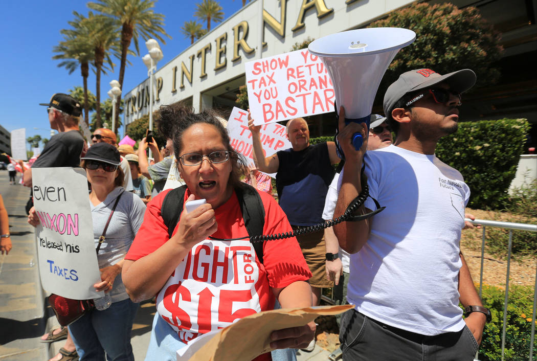 Diana Diaz, with Fight for $15, talks to demonstrators through a megaphone during a tax day pro ...