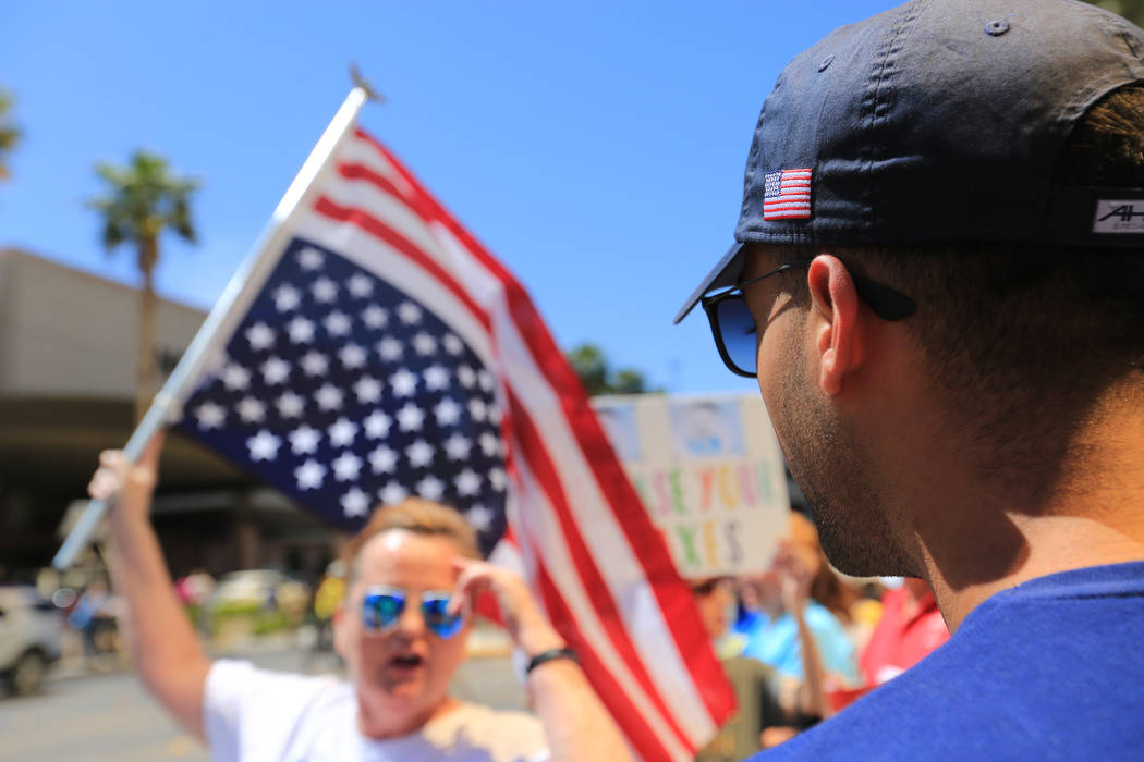 Daniel Naccarati, right, wearing hat with "Trump" and an American flag on it talks wi ...