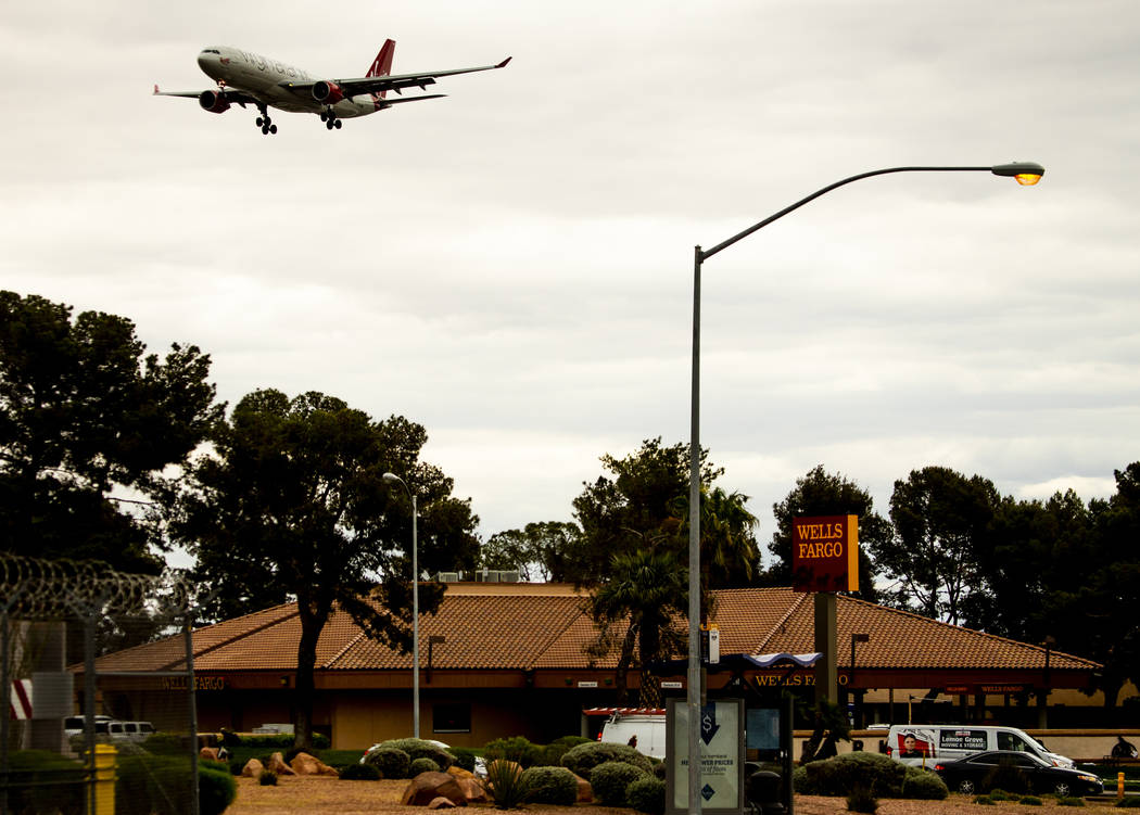 A plane flies low over Wells Fargo Bank near McCarran International Airport on Tuesday, April 1 ...