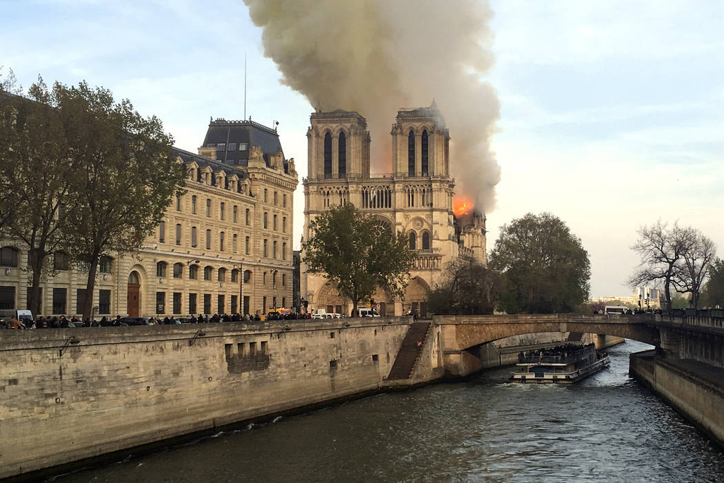 Notre Dame cathedral is burning in Paris, Monday, April 15, 2019. Massive plumes of yellow brow ...