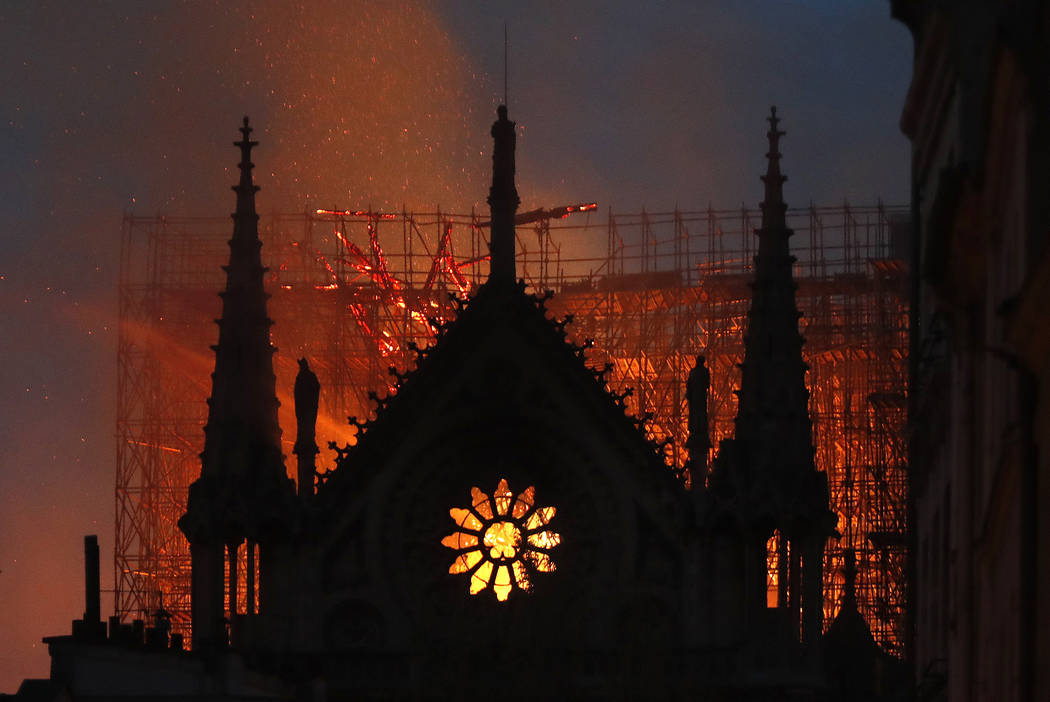 Flames and smoke rise from Notre Dame cathedral as it burns in Paris, Monday, April 15, 2019. M ...