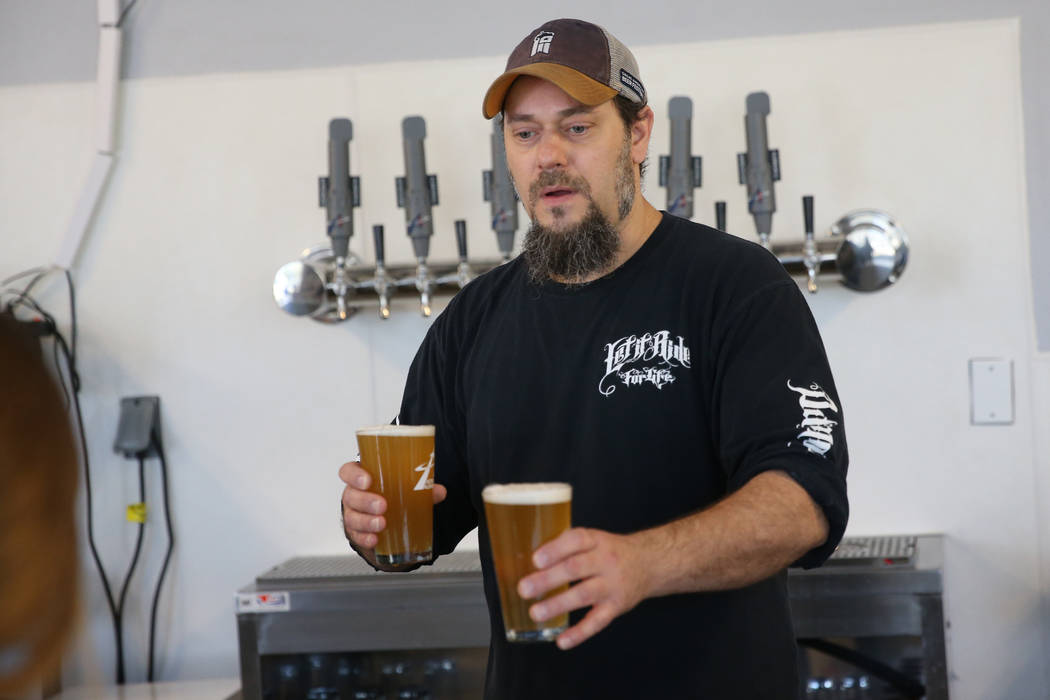 Allan Harrison, head brewer at Astronomy Ale Works, serves beers for customers, in Henderson, S ...
