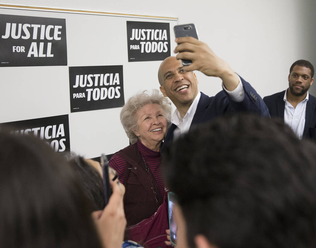 Democratic presidential candidate Sen. Cory Booker, D-N.J., takes photos with supporters at the ...