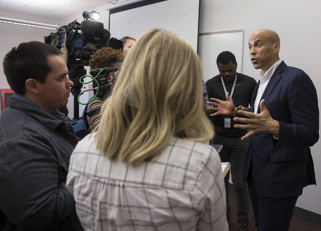 Democratic presidential candidate Sen. Cory Booker, right, D-N.J. takes questions from the medi ...