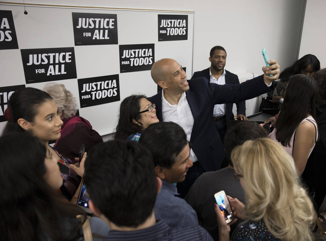 Democratic presidential candidate Sen. Cory Booker, D-N.J., takes photos with supporters at the ...