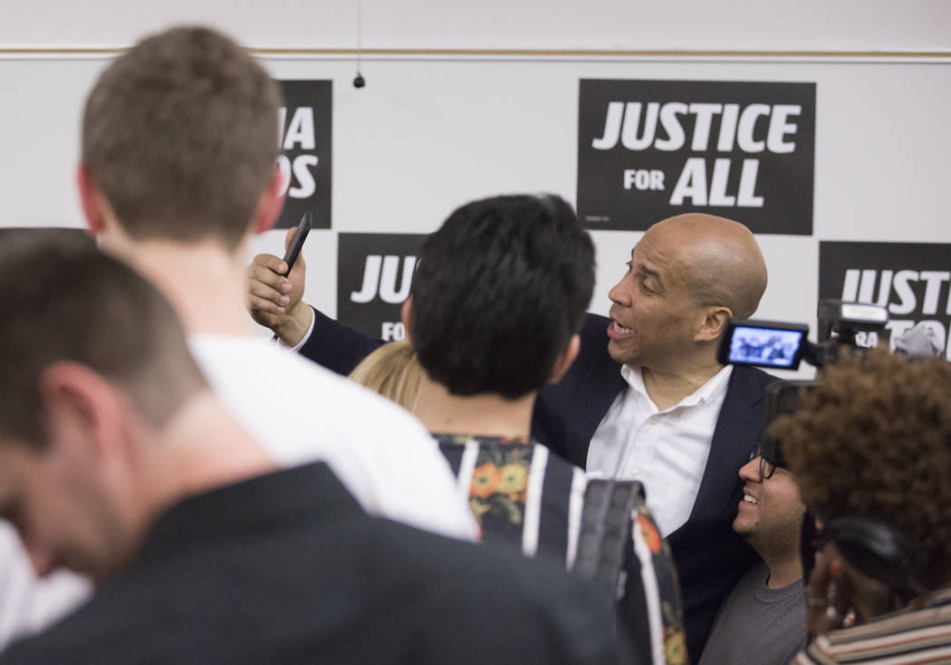 Democratic presidential candidate Sen. Cory Booker, D-N.J., takes photos with supporters at the ...