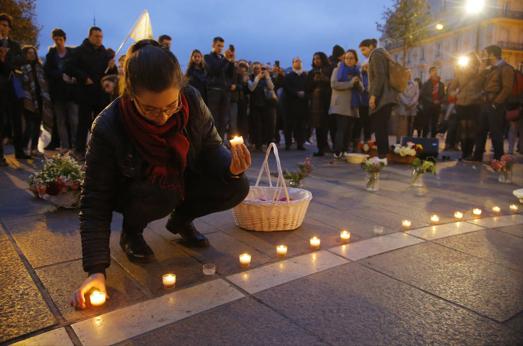 People gather ahead of a vigil at the Notre Dame Cathedral in Paris, Tuesday April 16, 2019. Fi ...