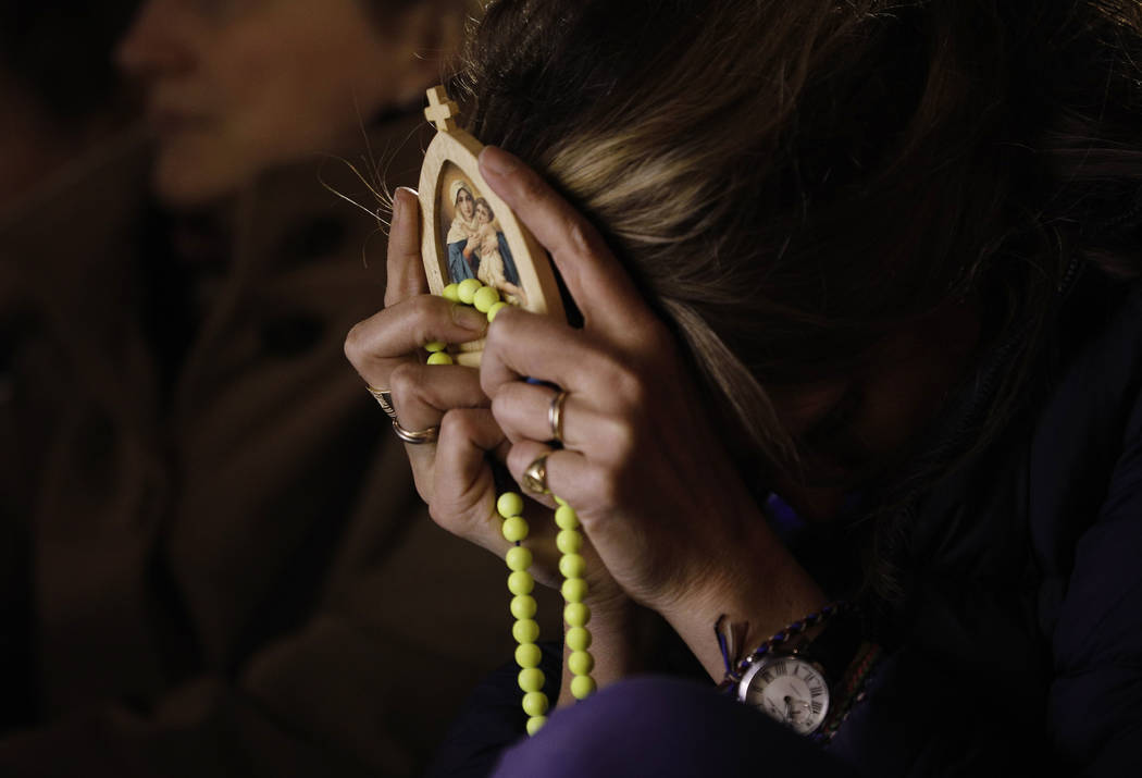 People attend a vigil in Paris, Tuesday April 16, 2019. Firefighters declared success Tuesday i ...