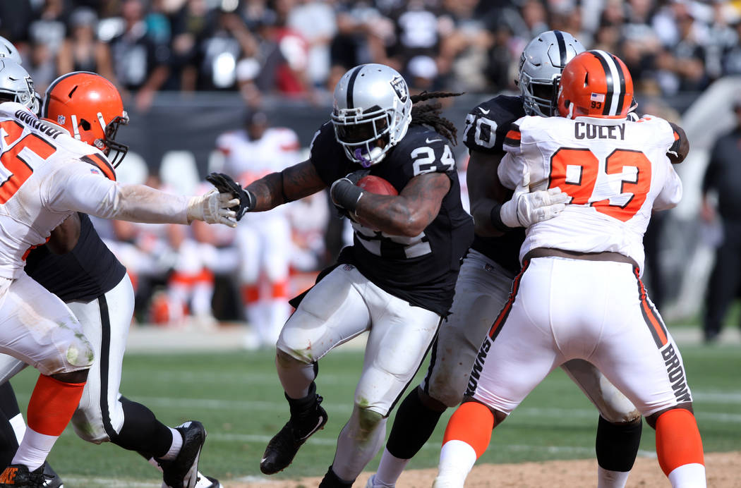 Oakland Raiders running back Marshawn Lynch (24) pushes away a hand from Cleveland Browns defen ...