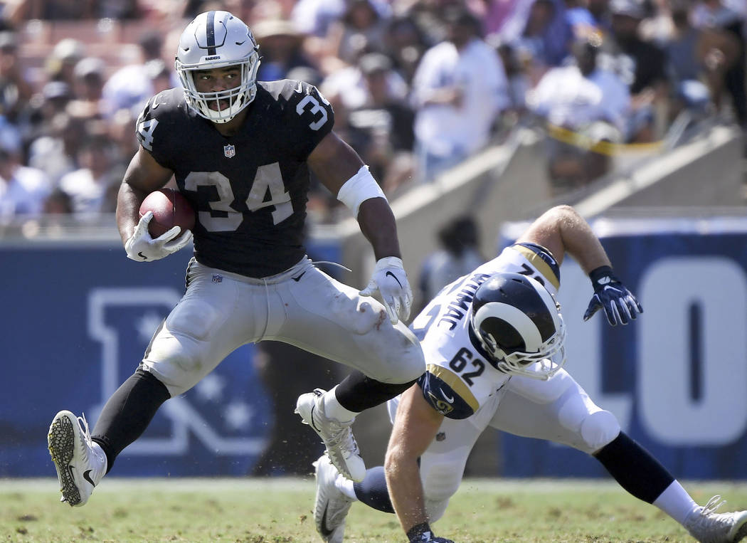 Oakland Raiders running back Chris Warren runs past Los Angeles Rams defensive end Brian Womac ...