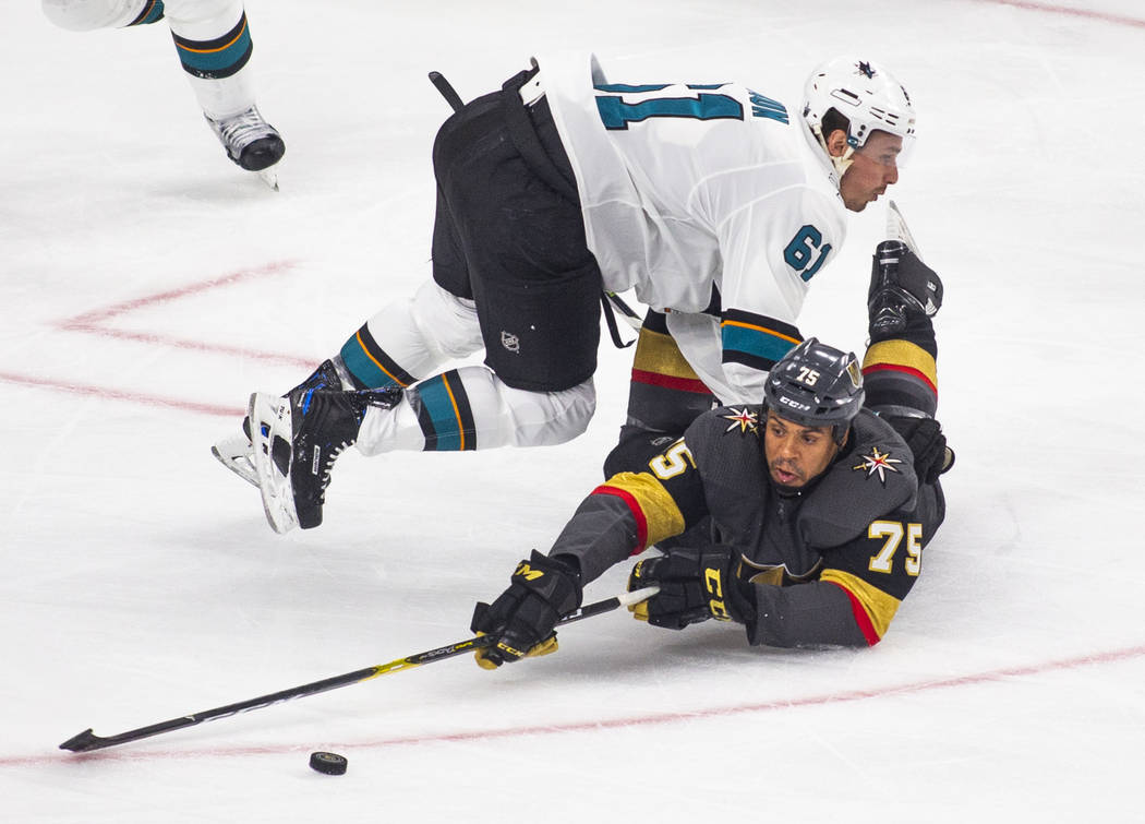 Golden Knights right wing Ryan Reaves (75) is taken to the ice by San Jose Sharks defenseman Ju ...