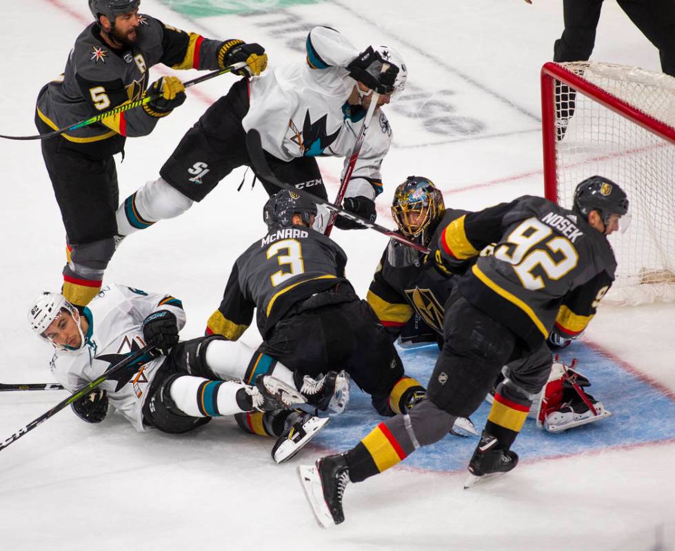 Golden Knights goaltender Marc-Andre Fleury (29) makes a stop amongst teammates and San Jose Sh ...