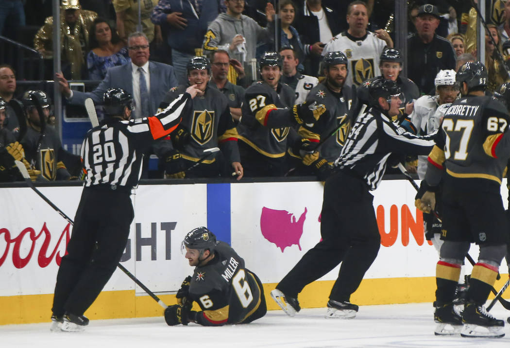 Golden Knights defenseman Colin Miller (6) is knocked to the ice by San Jose Sharks left wing E ...