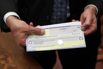 Gov. Brian Sandoval shows the $25,000,000 check from an anonymous donor for the UNLV medical sc ...