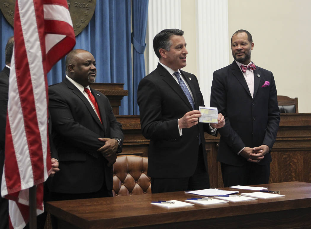 Gov. Brian Sandoval, third from left, holds up a $25,000,000 check from an anonymous donor for ...