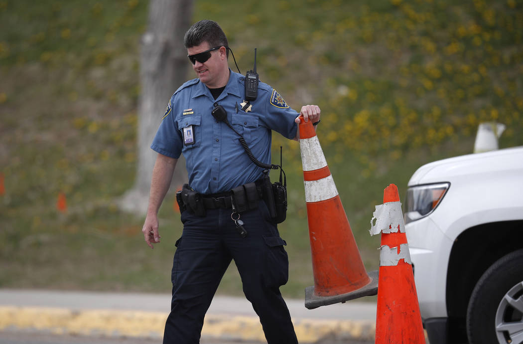 A Jefferson County, Colo. Schools officer blocks a driveway with a pylon outside Columbine High ...