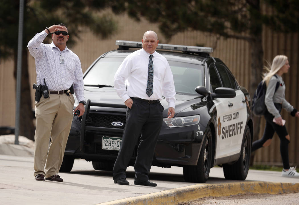 Columbine High School principal Scott Christy, right, joins an officer in watching as students ...