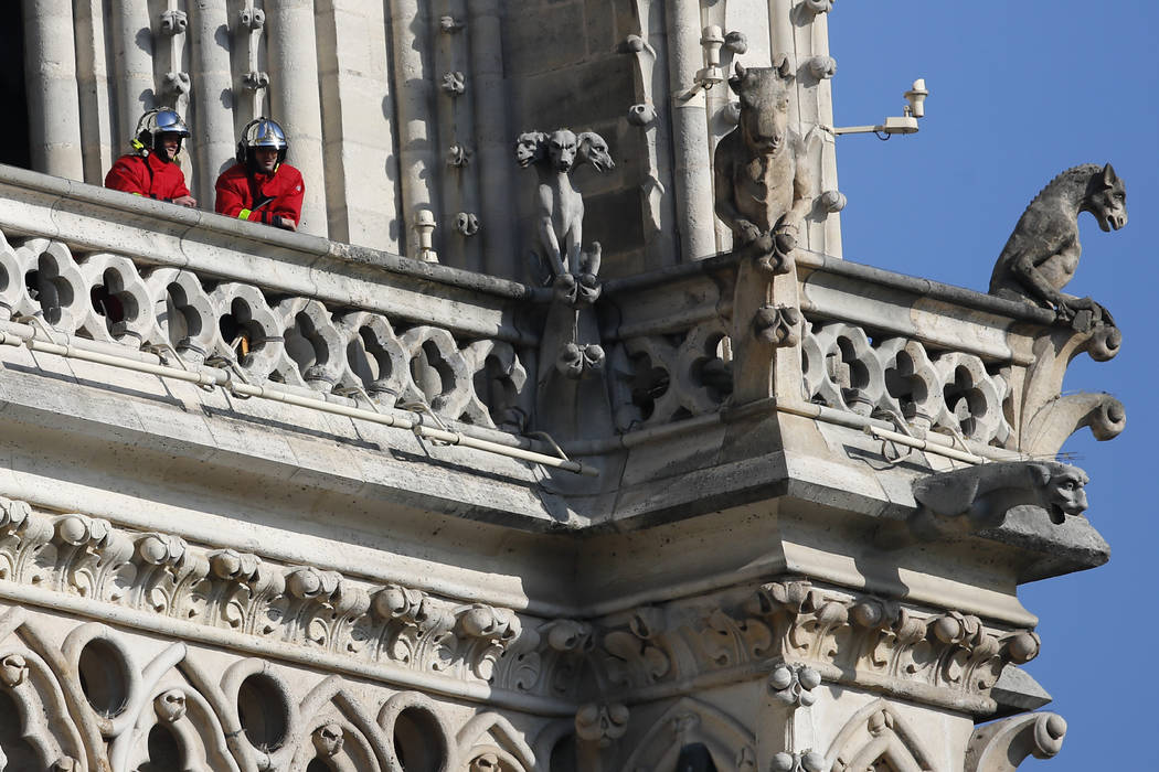 Firefighters wait at a balcony of Notre Dame cathedral Wednesday, April 17, 2019 in Paris. Near ...