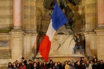 People attend a vigil in Paris, Tuesday April 16, 2019. Firefighters declared success Tuesday i ...