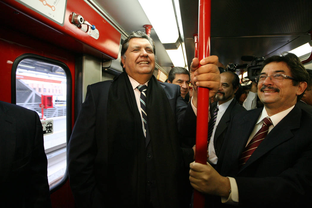 Peru President Alan Garcia, left, ride the soon to be inaugurated Line 1 electrical train syste ...