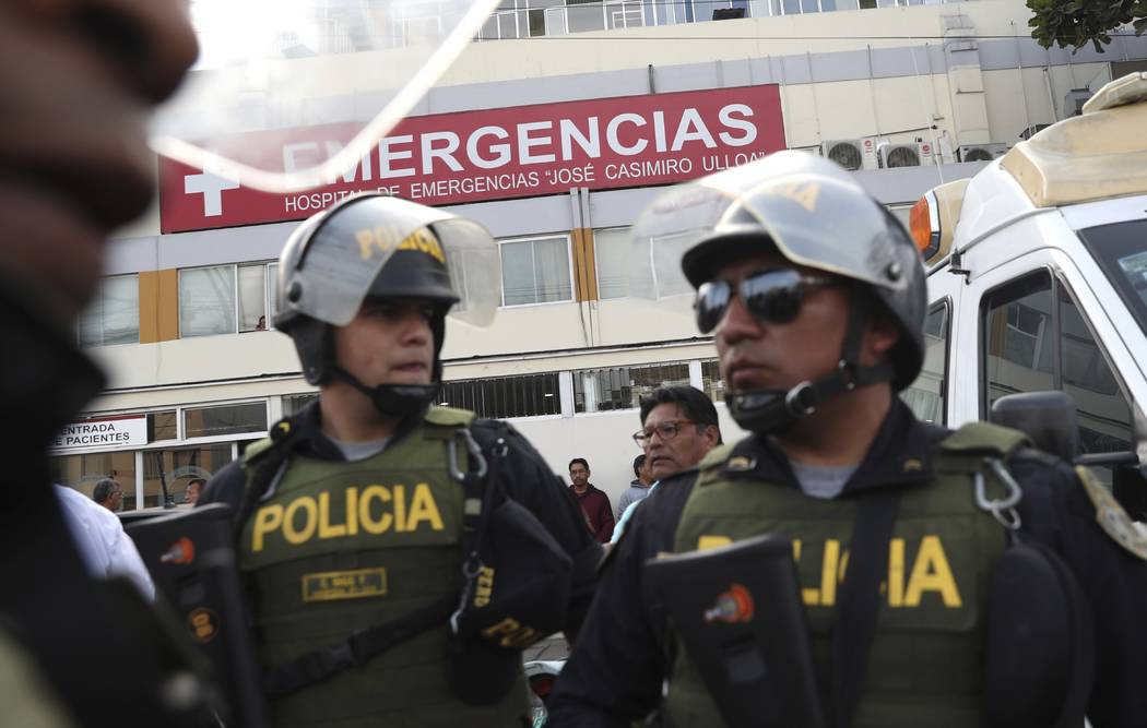 Police officers stand guard at the emergency entrance of the Casimiro Ulloa hospital where form ...