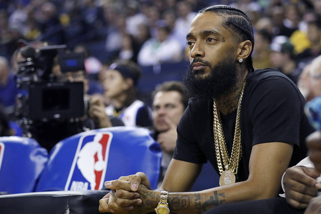 Rapper Nipsey Hussle watches an NBA basketball game between Golden State and Milwaukee in Oakla ...