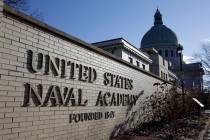 A sign stands outside of an entrance to the U.S. Naval Academy campus in Annapolis, Md., Thursd ...