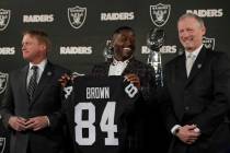 Oakland Raiders wide receiver Antonio Brown, center, holds his jersey beside coach Jon Gruden, ...