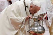 Pope Francis blows inside an amphora containing holy oil during a Chrism Mass inside St. Peter' ...