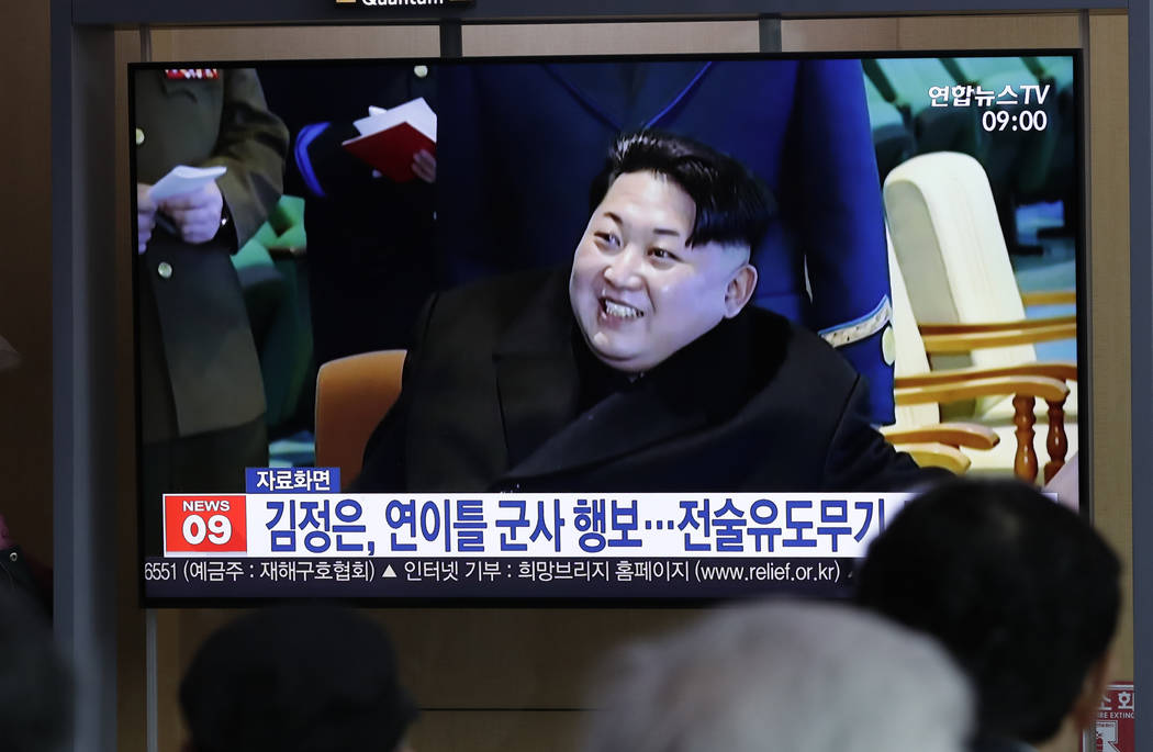 People watch a TV news program reporting about North Korea's test-fire of a "new-type tact ...