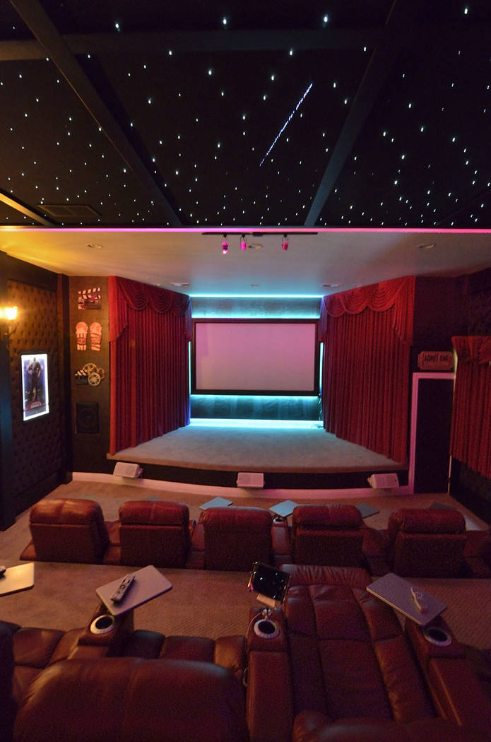 The theater walls are red velvet-tufted fabric, and one wall features faux leather paper. LED l ...