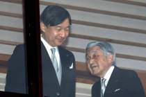 Japan's Emperor Akihito, right, accompanied by Crown Prince Naruhito, walks away after greeting ...