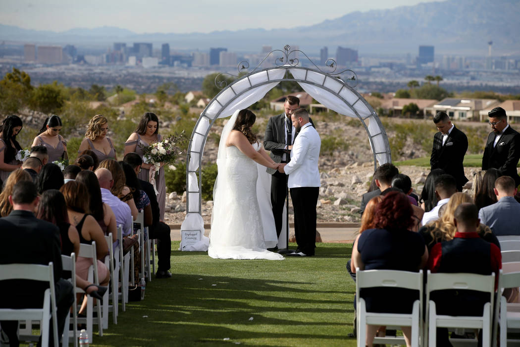 Kimberly and William King pray during their wedding ceremony at the Revere Golf Club in Henders ...