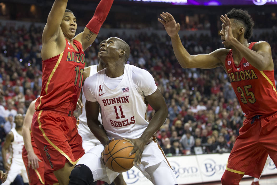 UNLV Rebels forward Cheickna Dembele (11) looks for a shot under pressure from Arizona Wildcats ...