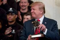 President Donald Trump holds up a statue of the Wounded Warrior Project logo presented to him d ...