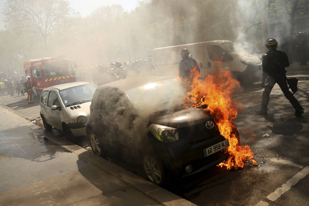 A car is set alight during a yellow vest demonstration in Paris, Saturday, April 20, 2019. Fren ...