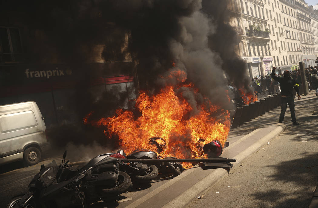 A set of motorbikes are set alight during a yellow vest demonstration in Paris, Saturday, April ...