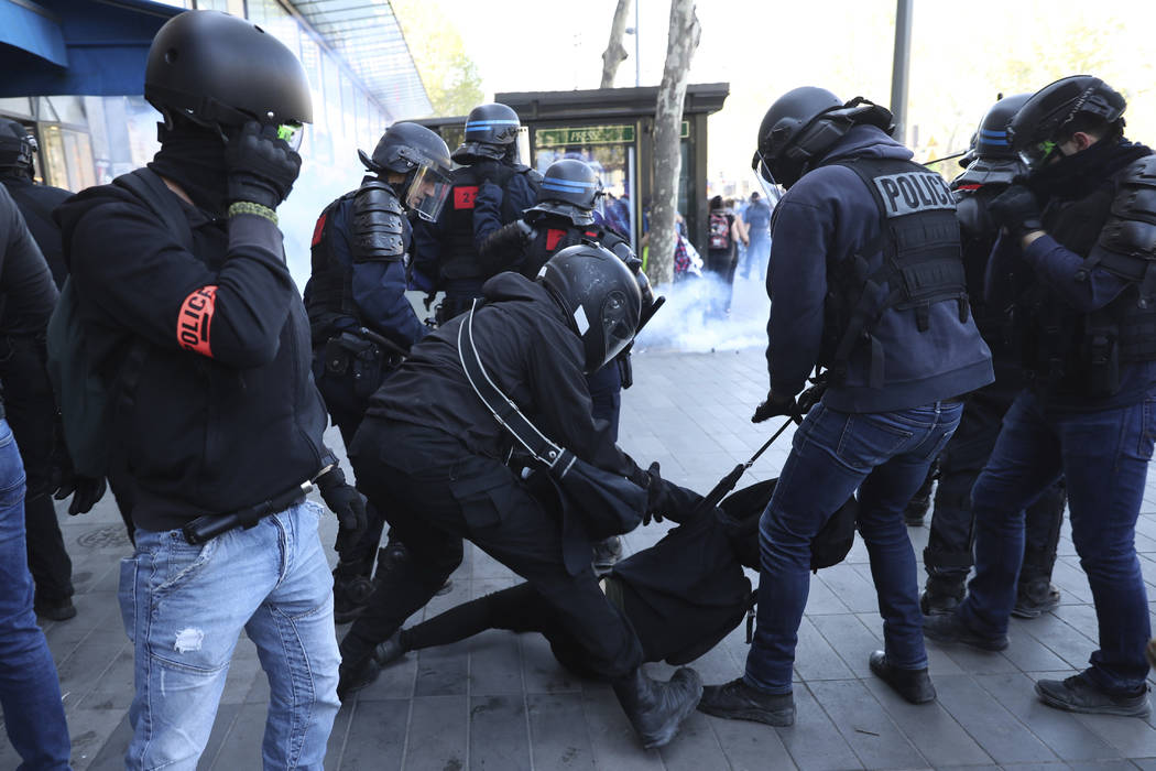 Police detain a protestor during a yellow vest demonstration in Paris, Saturday, April 20, 2019 ...