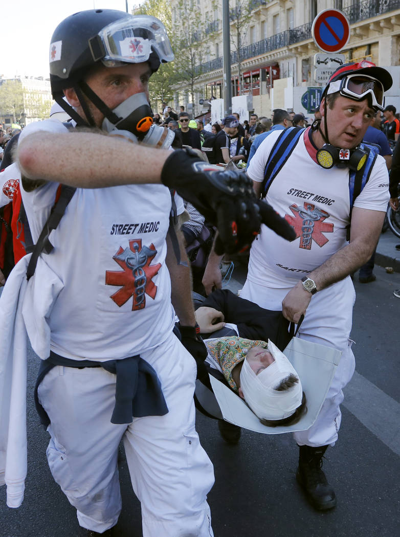 Street medics take away an injured man at Place de Republique during a yellow vest demonstratio ...