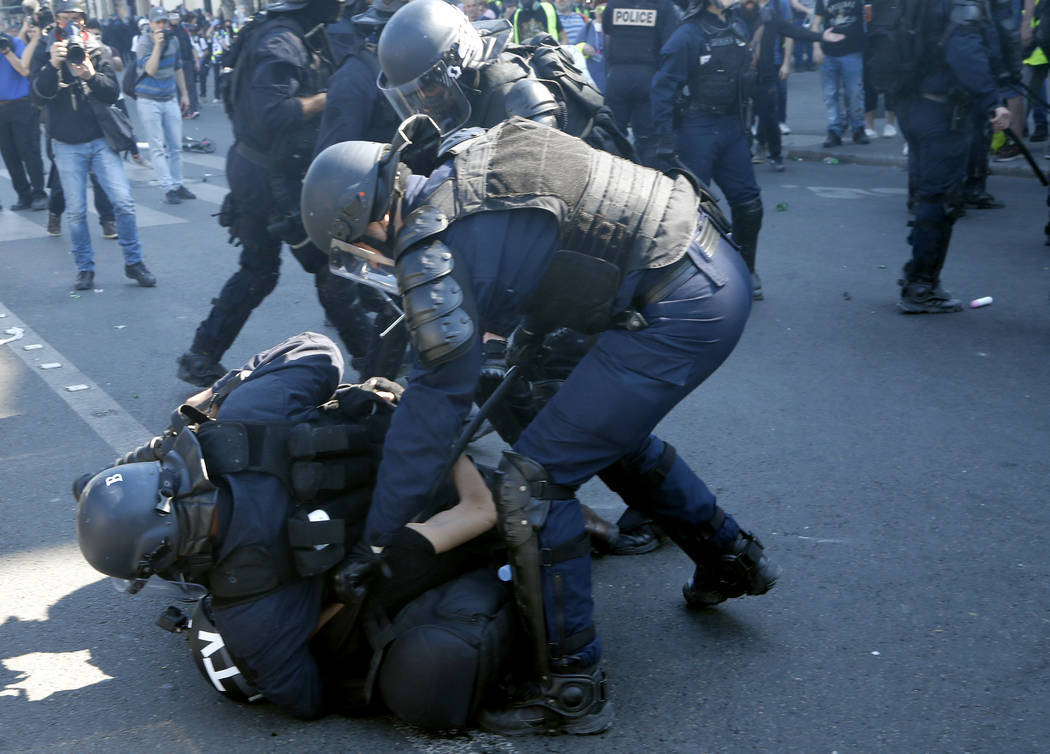 Police tackle a TV cameraman at the Place de Republique during a yellow vest demonstration in P ...