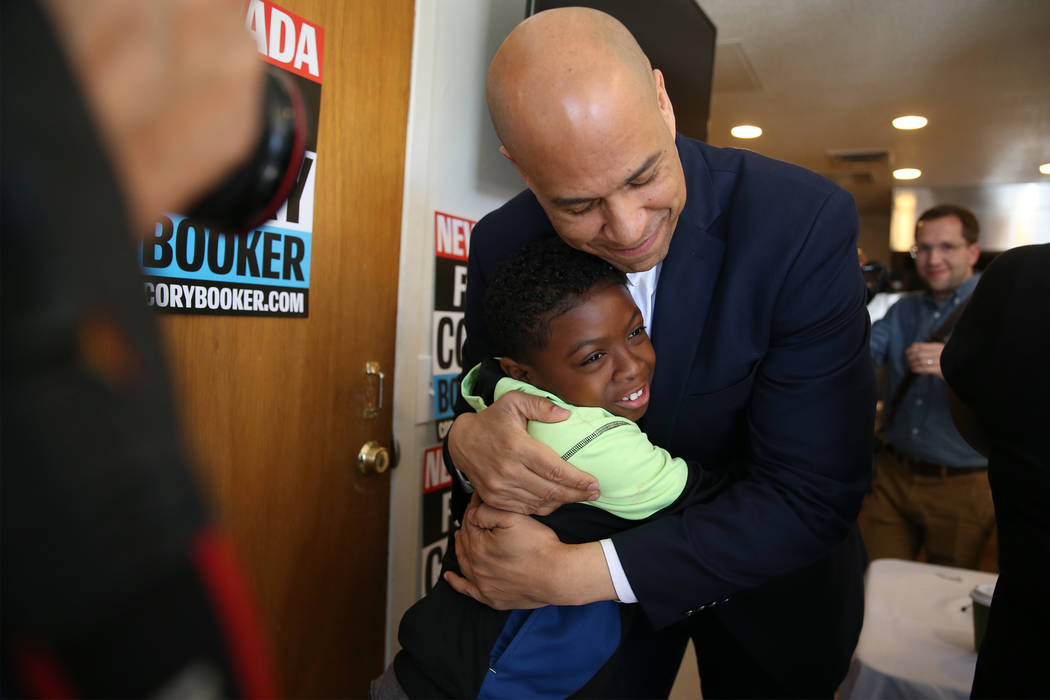 Democratic presidential candidate Sen. Cory Booker, D-N.J., hugs Jeremiah Daniels, 9, during an ...