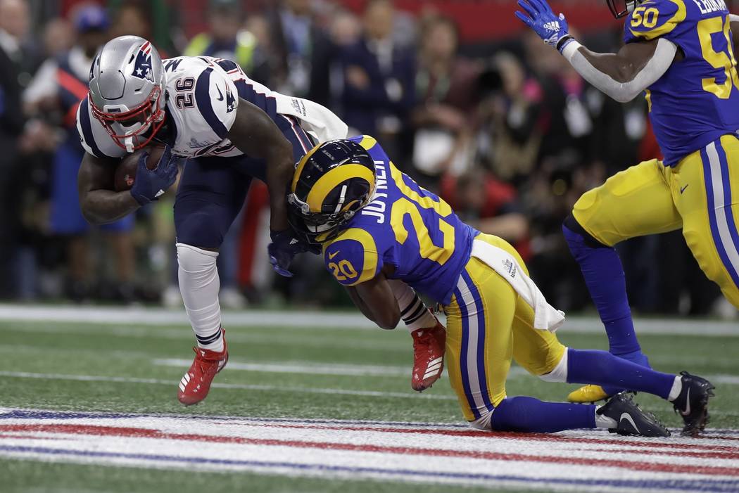 New England Patriots' Sony Michel (26) is tackled by Los Angeles Rams' Lamarcus Joyner (20) dur ...