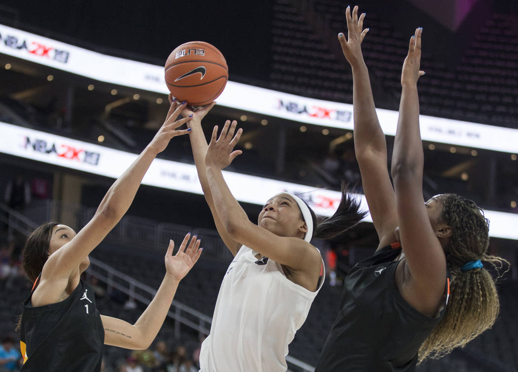 Zia Cooke (4) slices to the rim past Breanna Beal (1) and Lavender Briggs (23) in the second qu ...