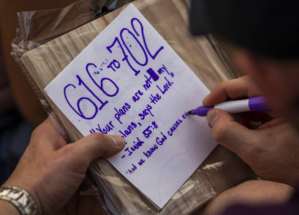 A participant creates a message on his paper lantern during the Water Lantern Festival at Sunse ...