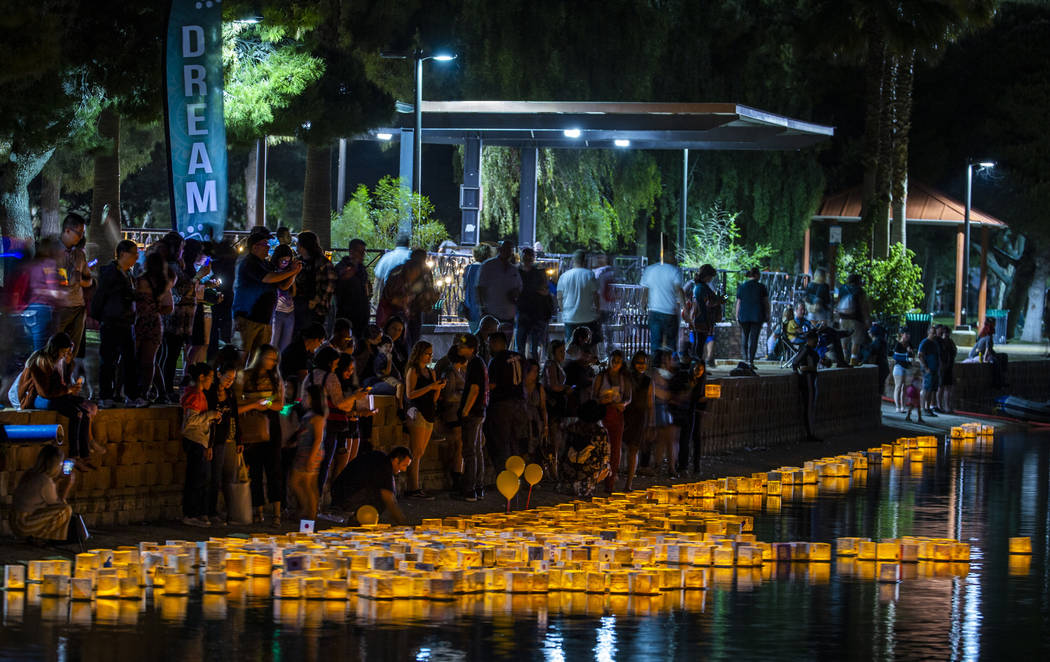 Participants stream down to the lake to launch lanterns during the Water Lantern Festival at Su ...