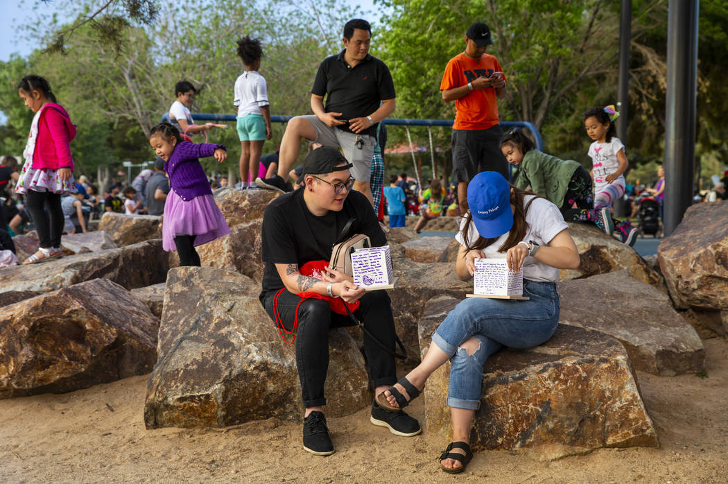 James Shoung looks on as Jennifer Nquyen constructs her lantern during the Water Lantern Festiv ...