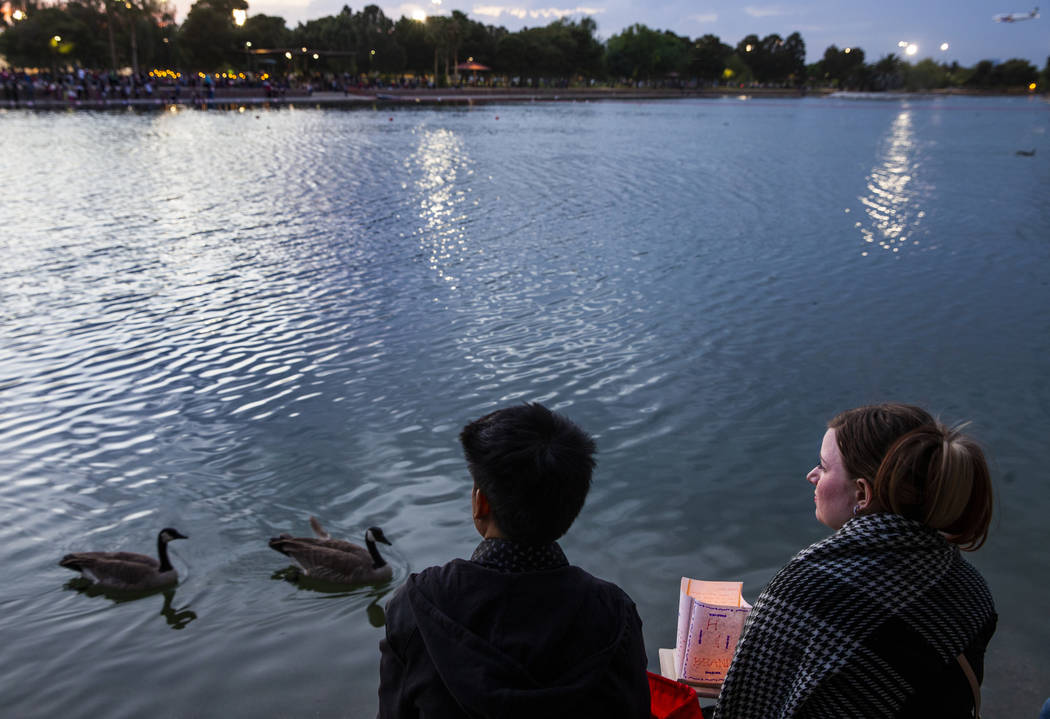 A couple look out over the lake as launching time nears during the Water Lantern Festival at Su ...