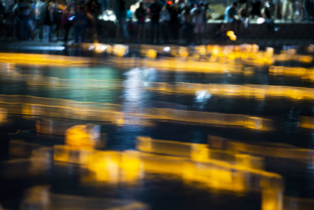 Lanterns stream about the lake in strong wind during the Water Lantern Festival at Sunset Park ...