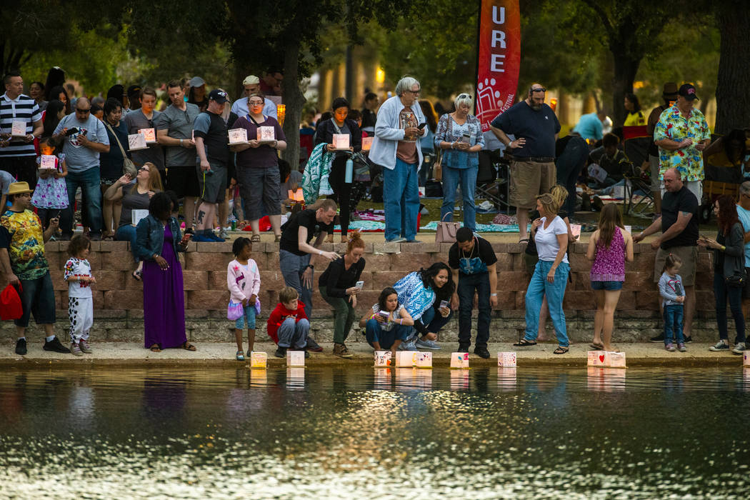 Participants gather at the lake edge to launch their lanterns during the Water Lantern Festival ...